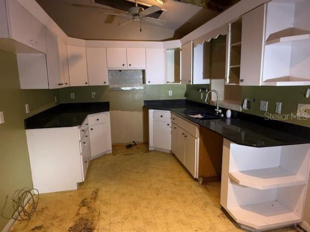 701 Madison Street Tavares, FL 32778 - Photo 4 of 12 a kitchen with stainless steel appliances a sink a stove a refrigerator cabinets and a dining table