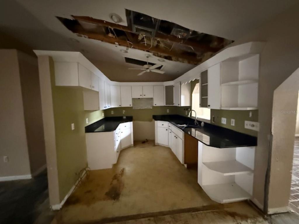 701 Madison Street Tavares, FL 32778 - Photo 5 of 12 a kitchen with stainless steel appliances granite countertop a sink a stove and a refrigerator