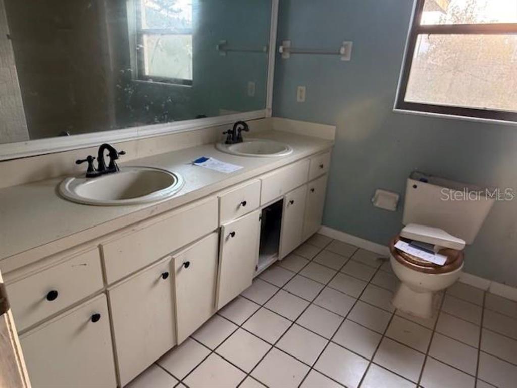 701 Madison Street Tavares, FL 32778 - Photo 7 of 12 a bathroom with a toilet sink and mirror