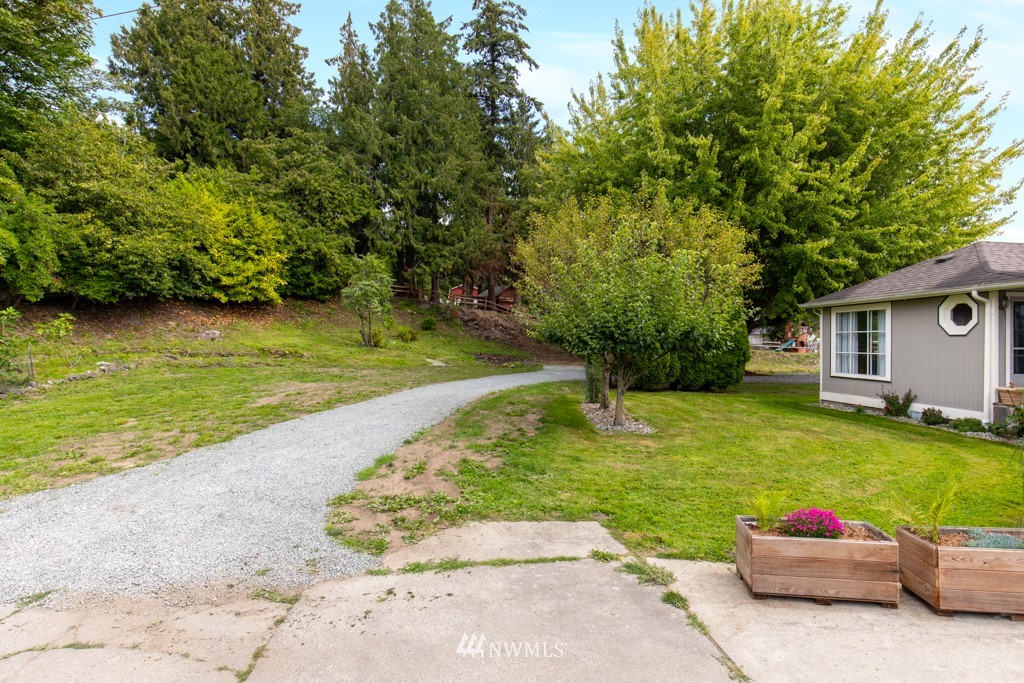 16722 Blodgett Road Mount Vernon, WA 98274 - Photo 5 of 37 a backyard of a house with plants and large trees