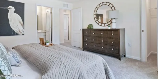 a bedroom with a bed a mirror and a table