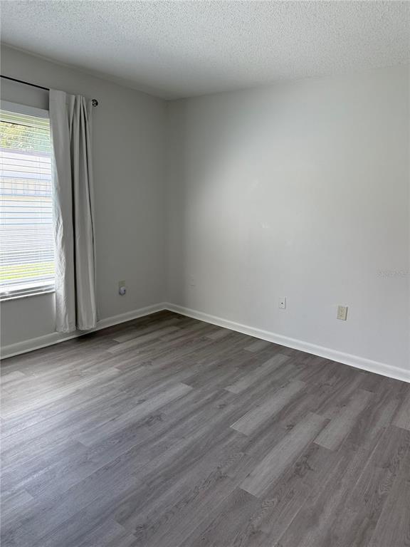 2207 Belleair Road, Unit B22 Clearwater, FL 33764 - Photo 6 of 17 an empty room with wooden floor and window