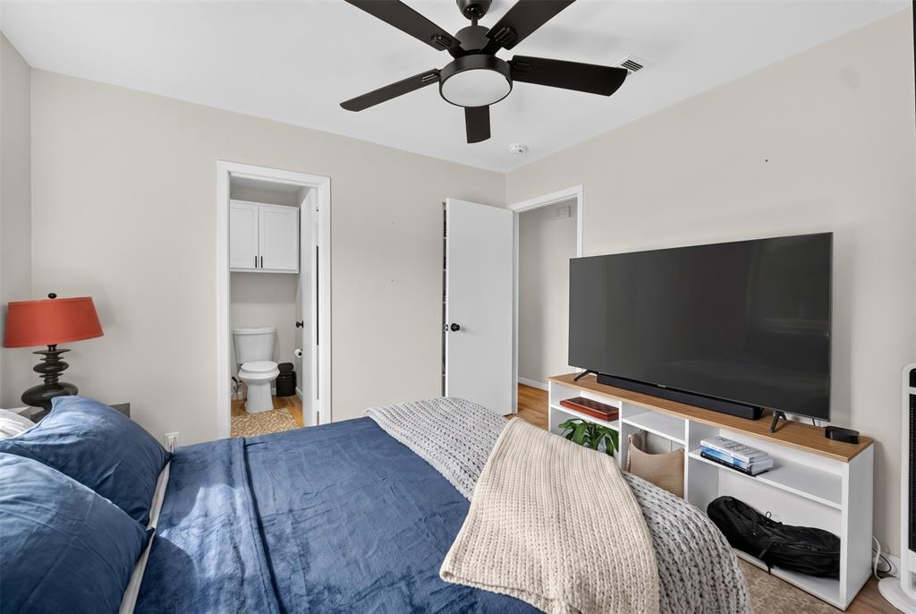3919 Ridgeoak Way Farmers Branch, TX 75244 - Photo 21 of 28 Bedroom featuring light neutral wall paint, a black ceiling fan, and wood-finish flooring
