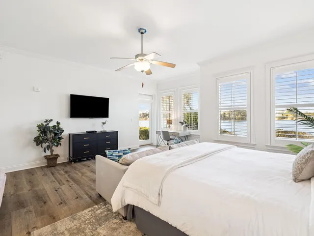 a bedroom with bed tv and a window