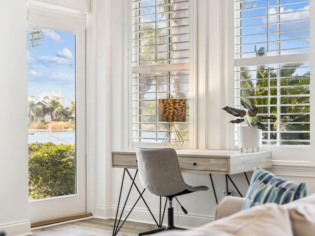 a dining room with furniture and large windows