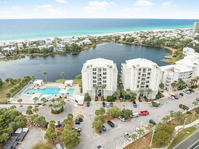 an aerial view of ocean and residential houses with outdoor space