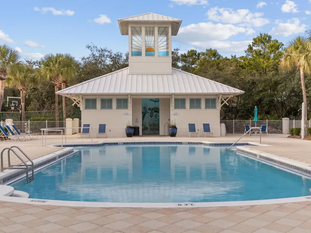 a view of a white house with a big yard and potted plants