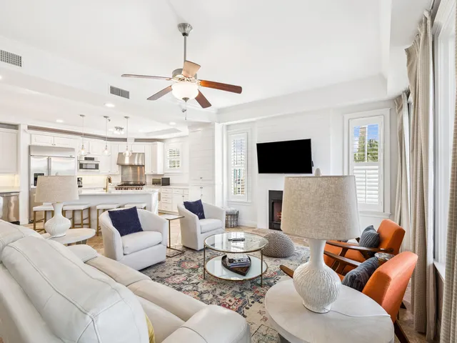 a living room with furniture kitchen view and a flat screen tv