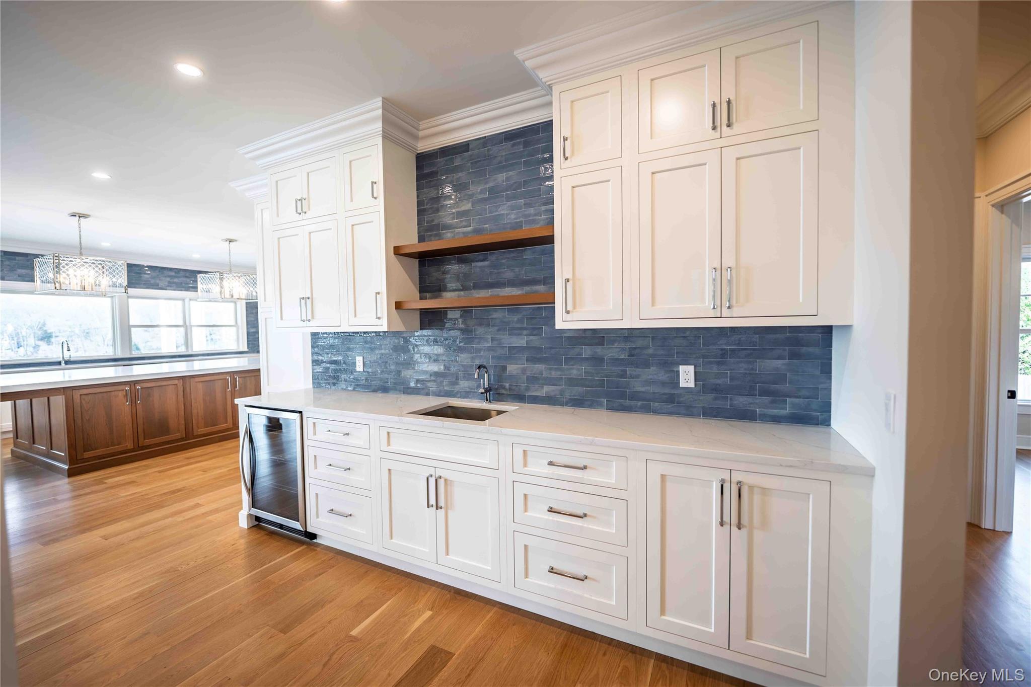 106 Cove Road Asharoken, NY 11768 - Photo 12 of 46 Dual tone kitchen featuring wine cooler, light stone counters, light wood finished floors, open shelves, and backsplash