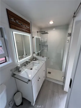 a bathroom with a sink vanity mirror and toilet