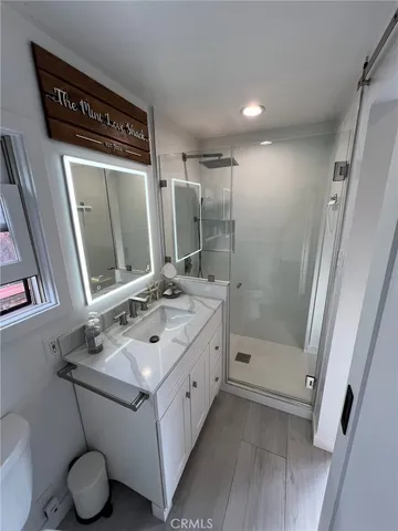 a bathroom with a sink vanity mirror and toilet