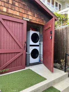 a backyard of a house with barbeque oven and fence