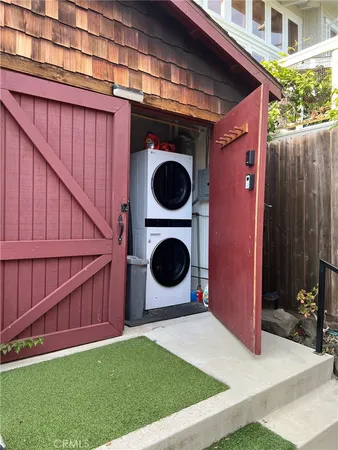 a backyard of a house with barbeque oven and fence
