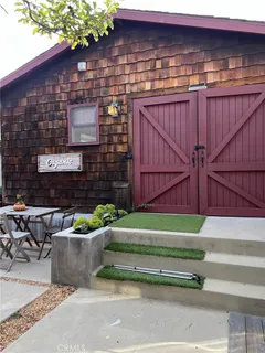 a backyard of a house with barbeque oven table and chairs