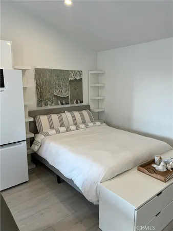 a bed sitting in a bedroom next to a window