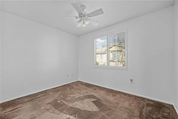 an empty room with fan and windows