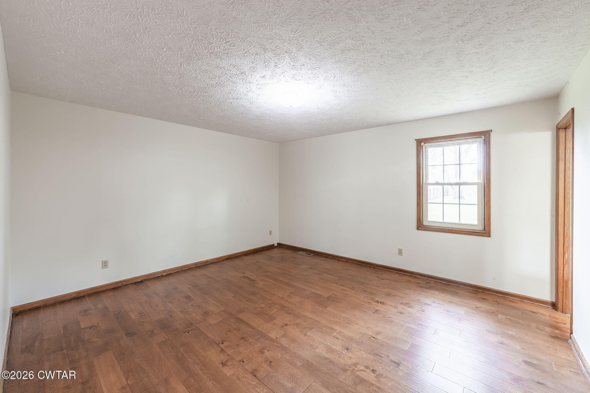 222 Dustin Drive Jackson, TN 38301 - Photo 20 of 30 an empty room with wooden floor and windows in it