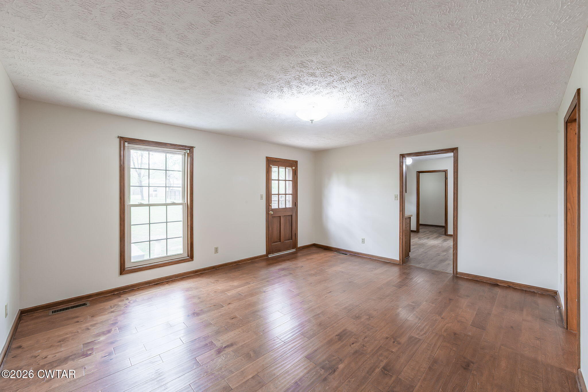 222 Dustin Drive Jackson, TN 38301 - Photo 2 of 30 an empty room with wooden floor and windows