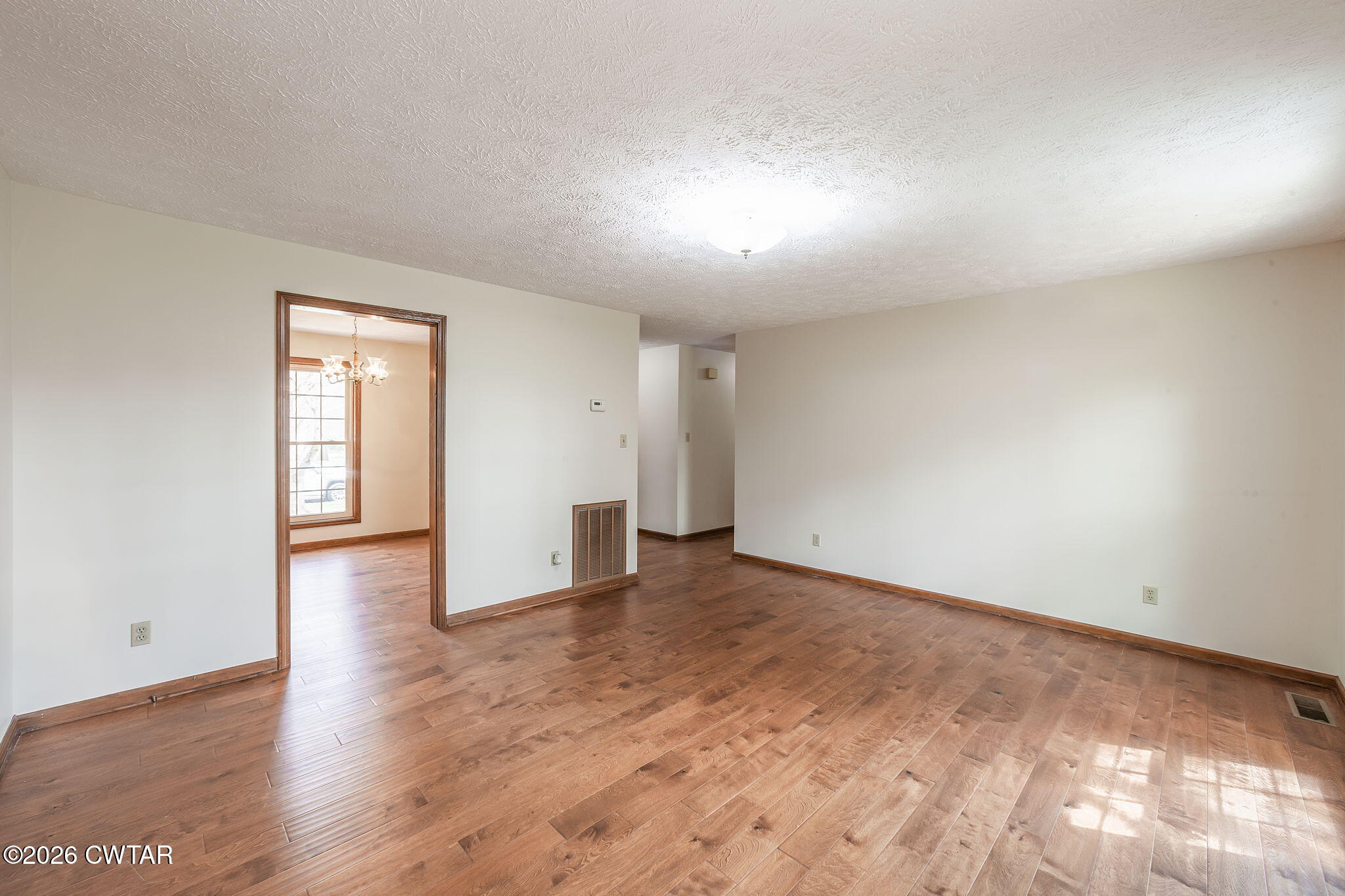 222 Dustin Drive Jackson, TN 38301 - Photo 4 of 30 a view of an empty room with wooden floor and a window