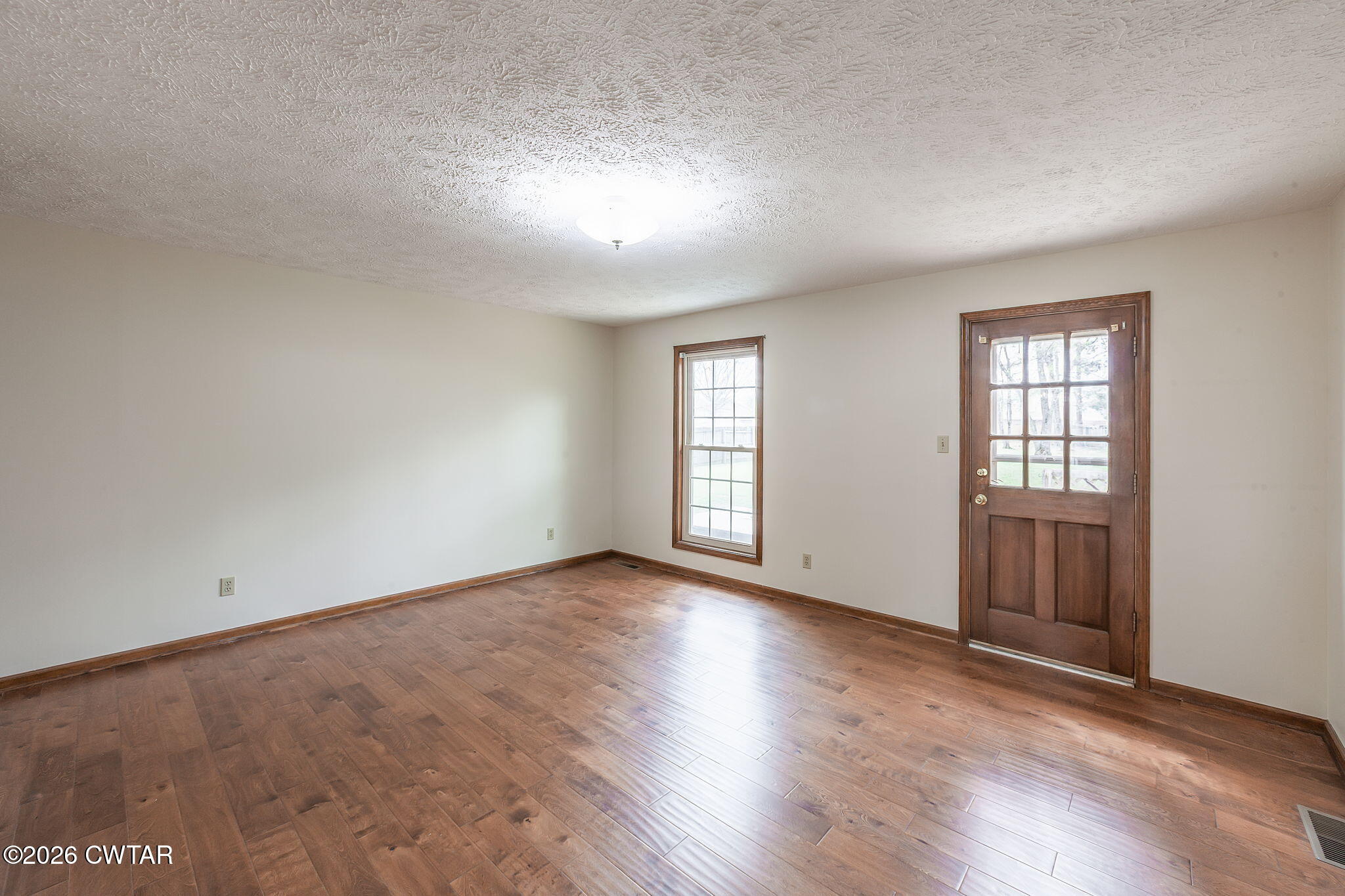 222 Dustin Drive Jackson, TN 38301 - Photo 5 of 30 an empty room with wooden floor and windows