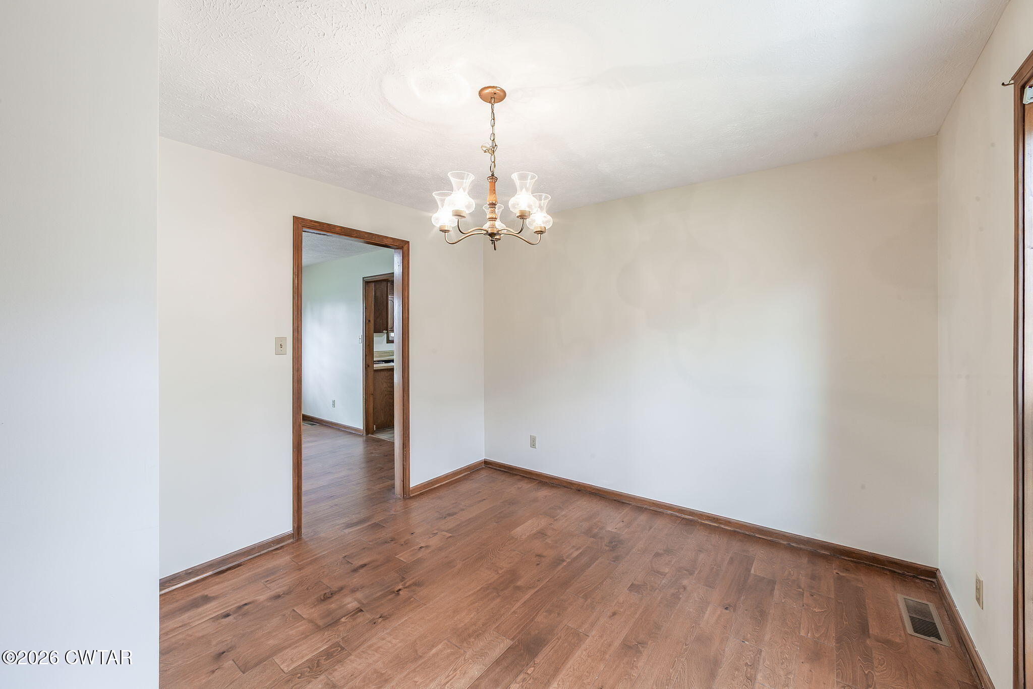 222 Dustin Drive Jackson, TN 38301 - Photo 7 of 30 an empty room with wooden floor and chandelier