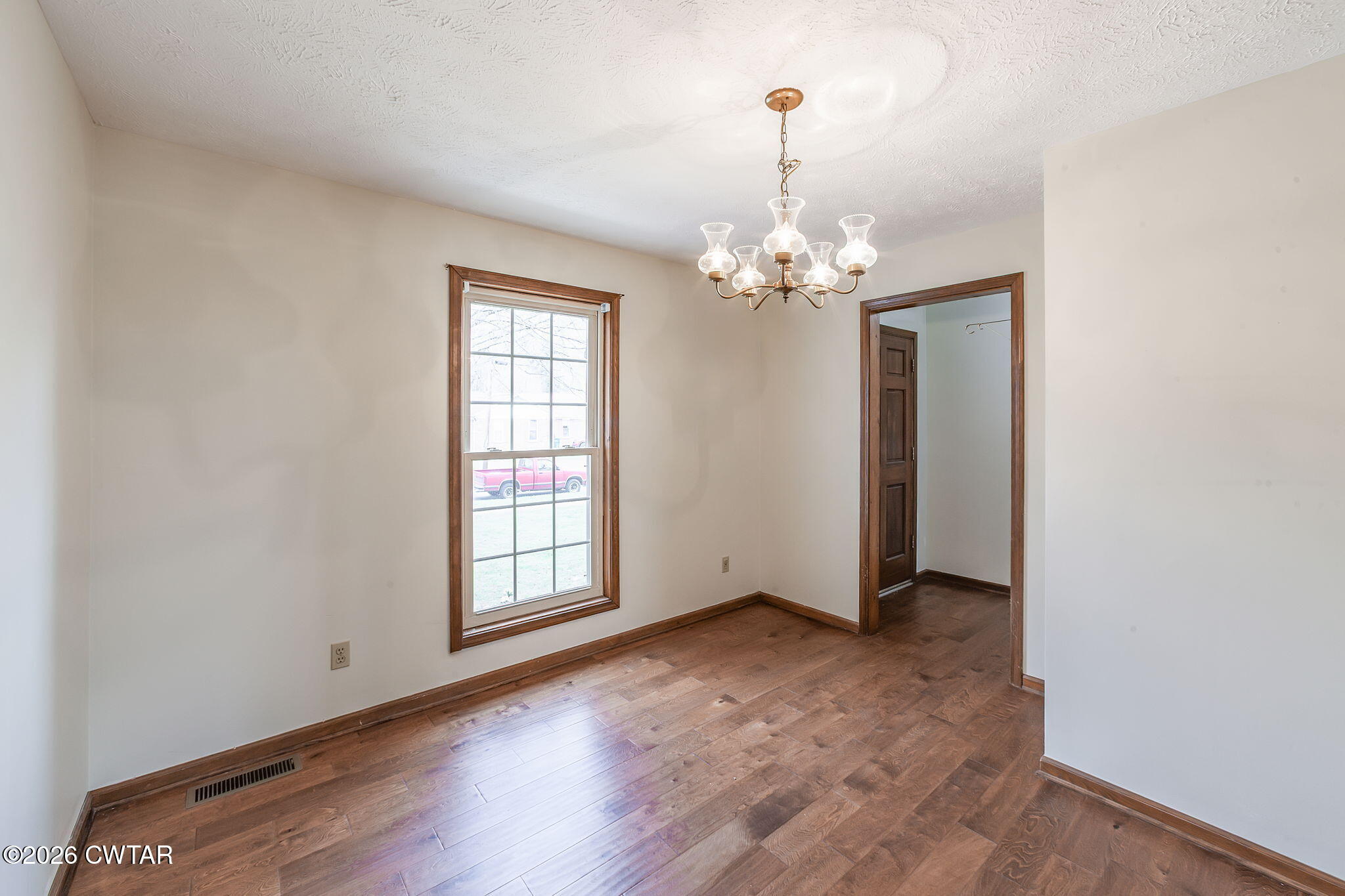 222 Dustin Drive Jackson, TN 38301 - Photo 9 of 30 an empty room with wooden floor chandelier and windows