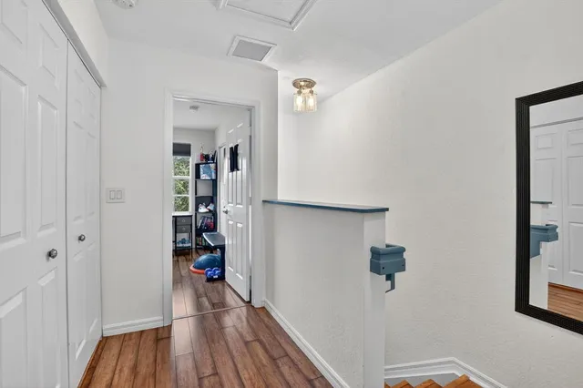 a view of a hallway with wooden floor and closet