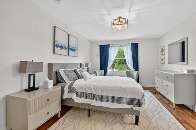 a bedroom with a bed and a flat tv screen on dresser
