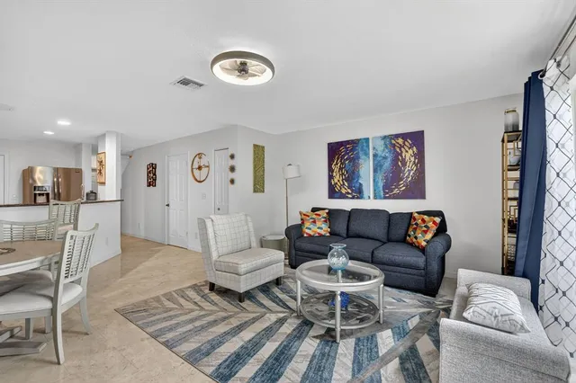 a living room with furniture and kitchen view