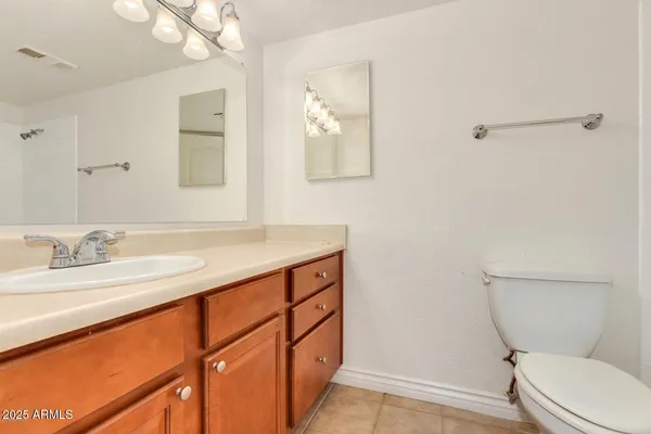 a bathroom with a granite countertop sink mirror vanity and toilet