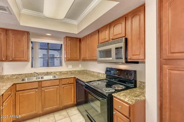 a kitchen with granite countertop a stove sink and cabinets