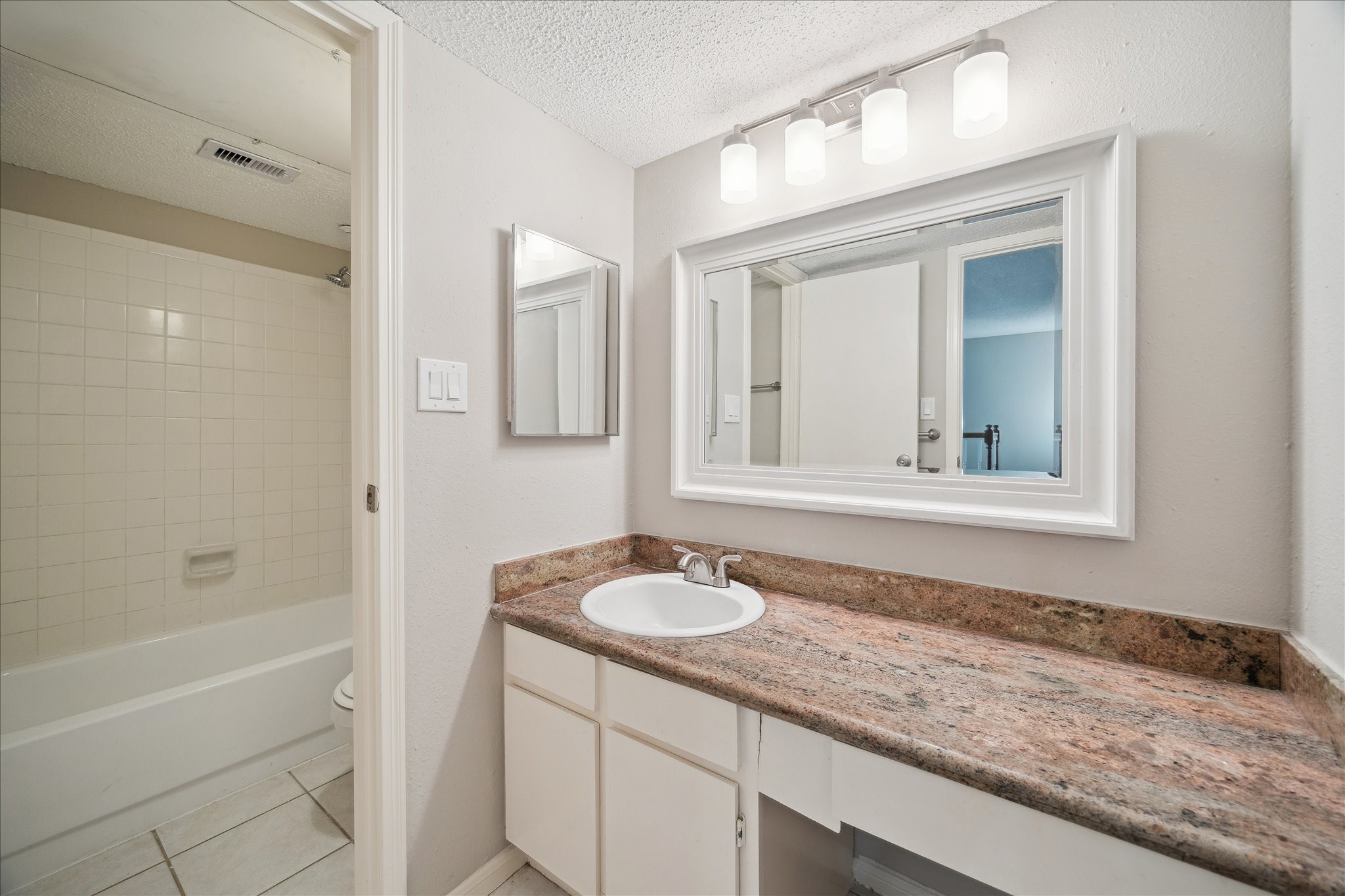 7575 Cambridge Street, Unit 1003 Houston, TX 77054 - Photo 23 of 27 a bathroom with a granite countertop sink and a mirror