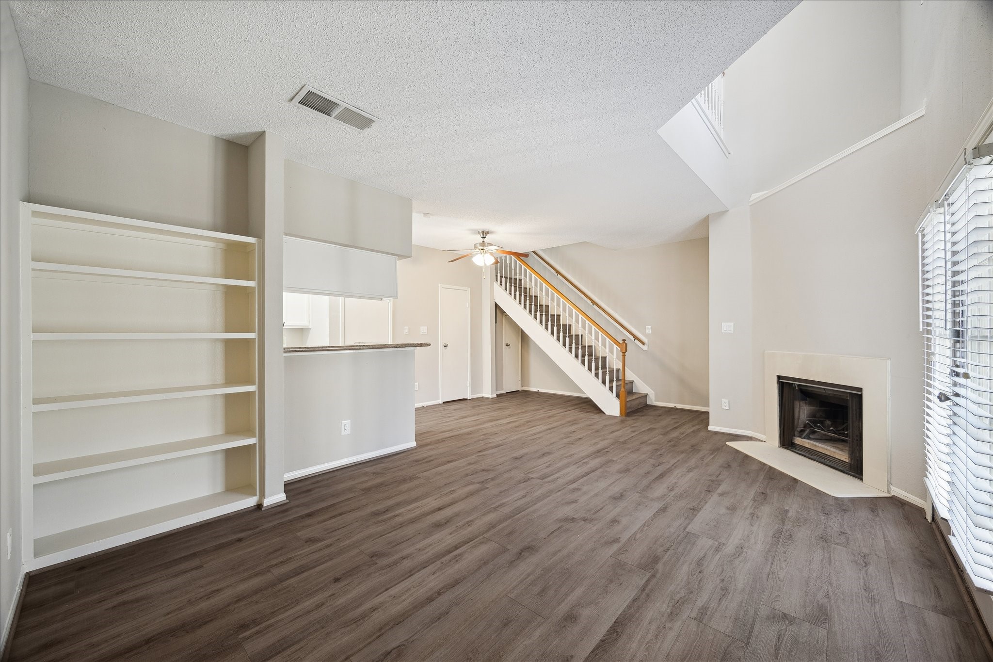 7575 Cambridge Street, Unit 1003 Houston, TX 77054 - Photo 8 of 27 a view of an empty room with wooden floor fireplace and a window