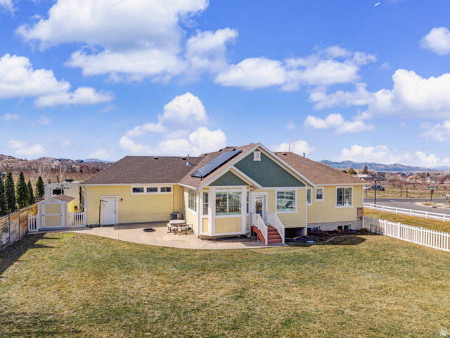 968 South Cyn Road Santaquin, UT 84655 - Photo 31 of 36 Rear exterior featuring a spacious concrete patio, a sunroom with multiple windows, and a storage shed