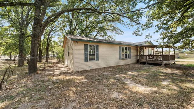 a view of a house with a large tree and a yard