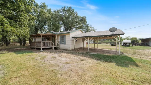 a view of a house with backyard and sitting area
