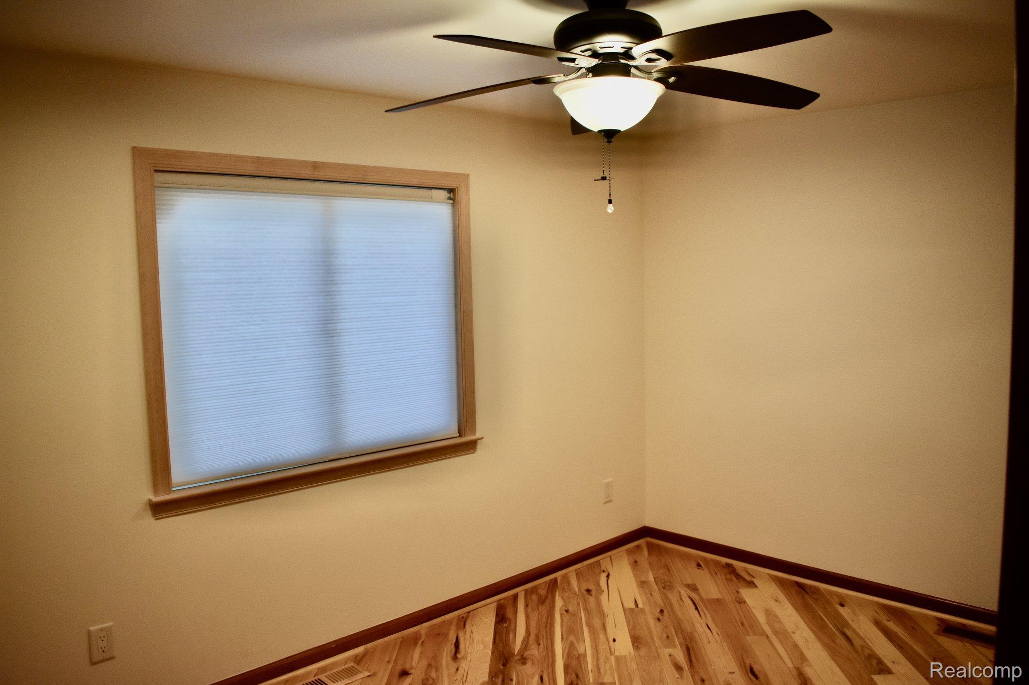 8312 Whitmore Lake Road Brighton, MI 48116 - Photo 35 of 43 Wood-finish flooring, ceiling fan with integrated lighting, wood window trim, and neutral wall tones