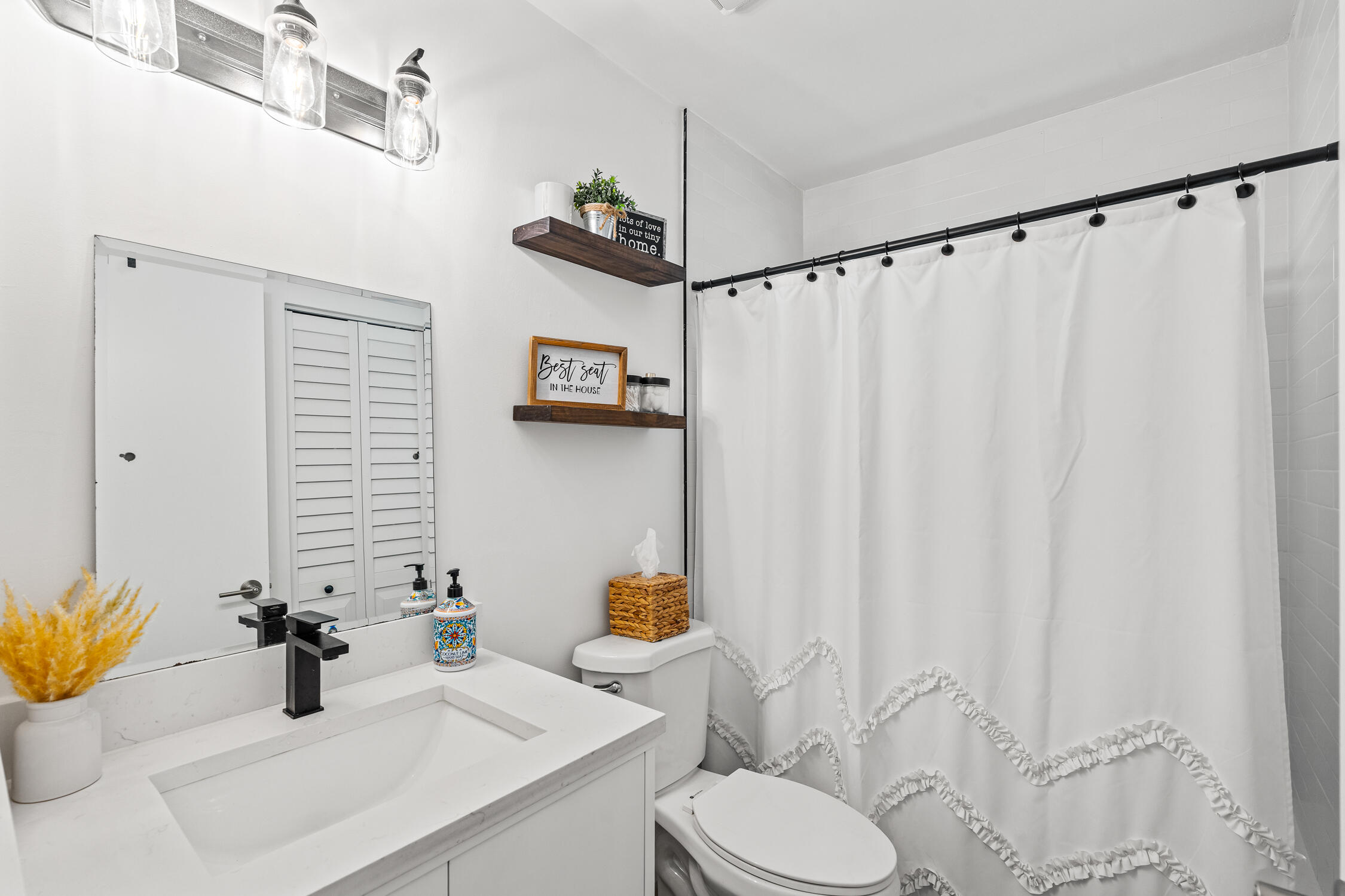 23368 Southwest 53rd Avenue, Unit C Boca Raton, FL 33433 - Photo 20 of 32 a bathroom with a sink a toilet and shower curtain