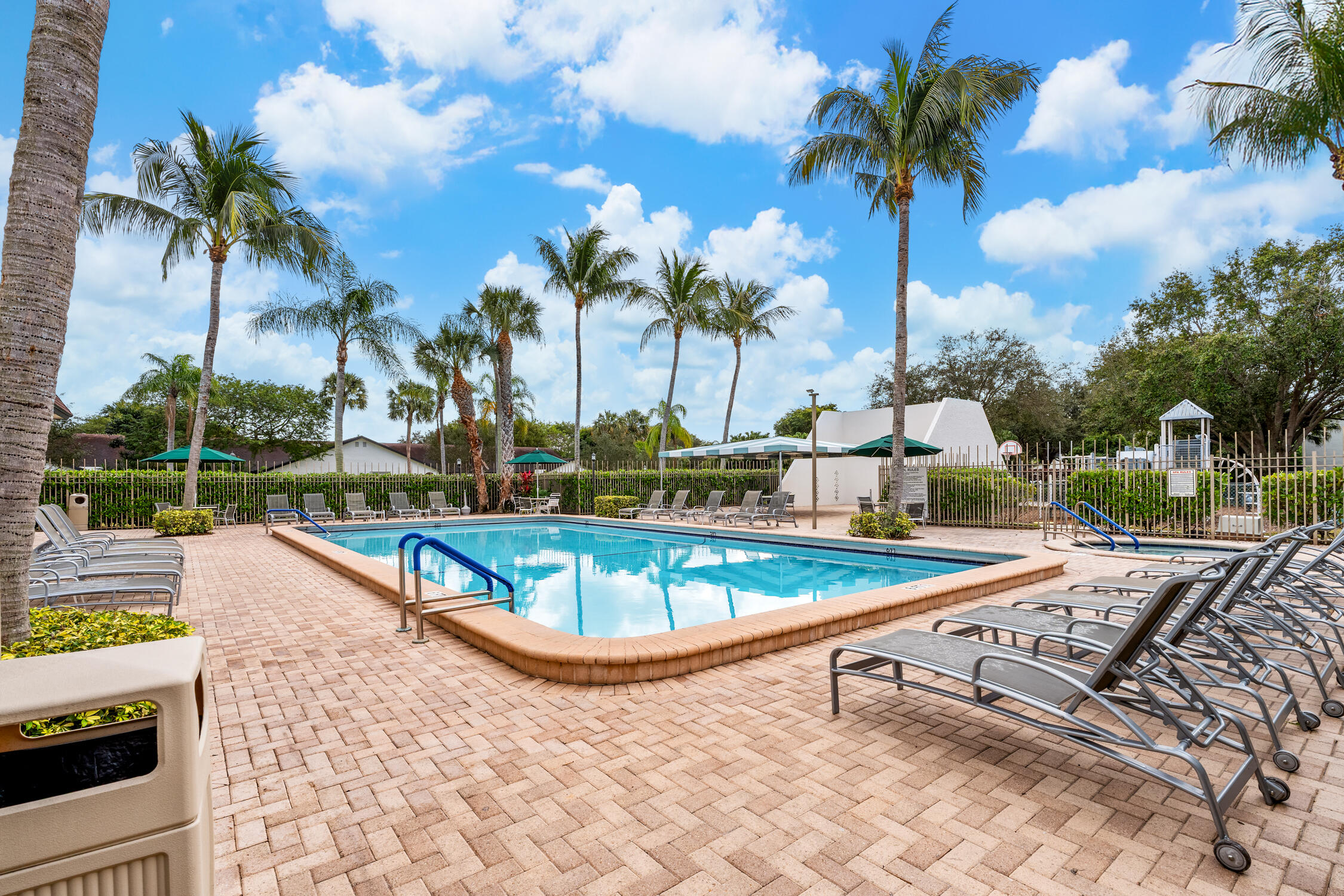 23368 Southwest 53rd Avenue, Unit C Boca Raton, FL 33433 - Photo 26 of 32 a view of a swimming pool with a patio and a garden