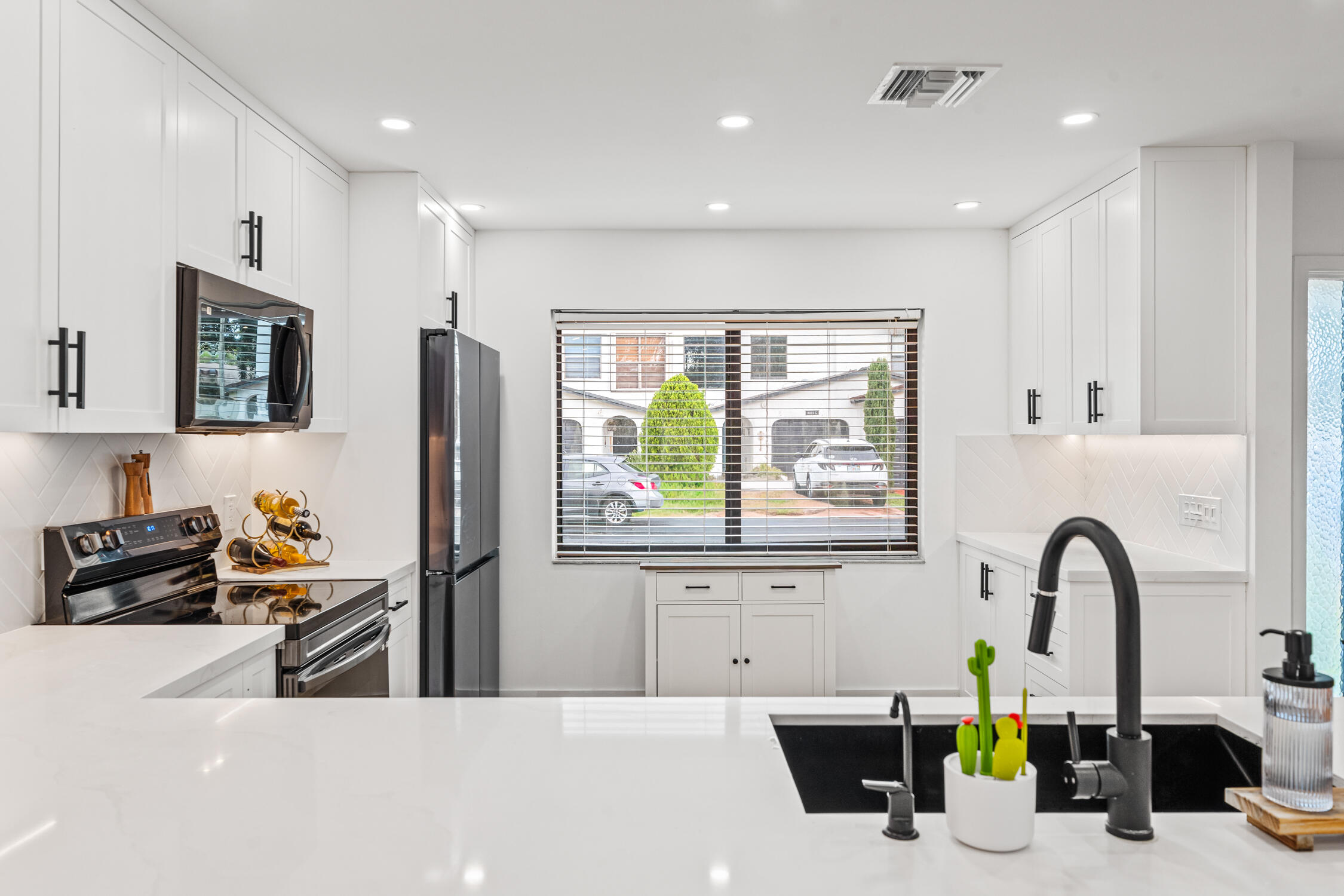 23368 Southwest 53rd Avenue, Unit C Boca Raton, FL 33433 - Photo 5 of 32 a kitchen with stainless steel appliances a sink a counter space and a window