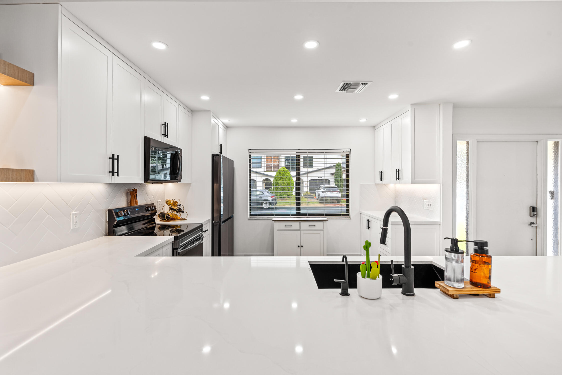 23368 Southwest 53rd Avenue, Unit C Boca Raton, FL 33433 - Photo 6 of 32 a kitchen with stainless steel appliances a sink and microwave