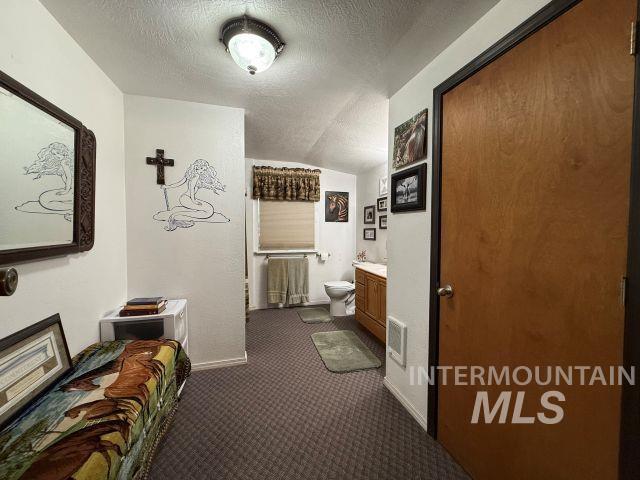 848 Jonathan Road Weiser, ID 83672 - Photo 11 of 42 Hallway with a textured ceiling and dark colored carpet