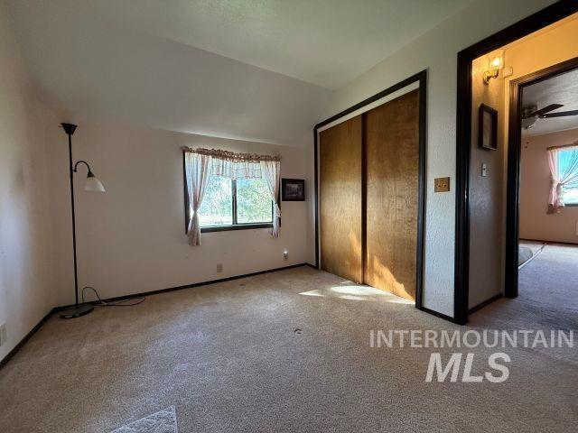 848 Jonathan Road Weiser, ID 83672 - Photo 15 of 42 Unfurnished bedroom featuring carpet floors, multiple windows, a closet, and vaulted ceiling