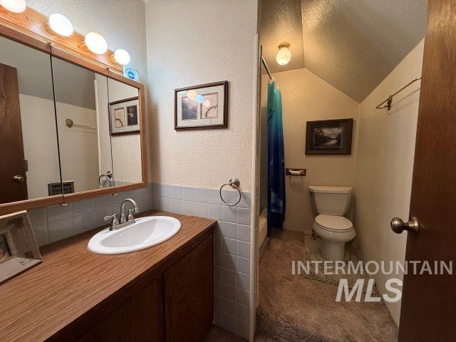 848 Jonathan Road Weiser, ID 83672 - Photo 20 of 42 Full bathroom with vanity, lofted ceiling, a textured wall, and shower / bath combo with shower curtain