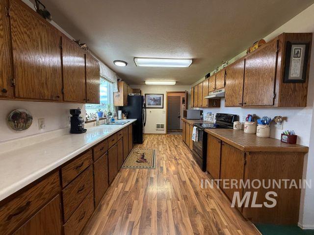 848 Jonathan Road Weiser, ID 83672 - Photo 2 of 42 Kitchen with black appliances, light wood-type flooring, and a textured ceiling