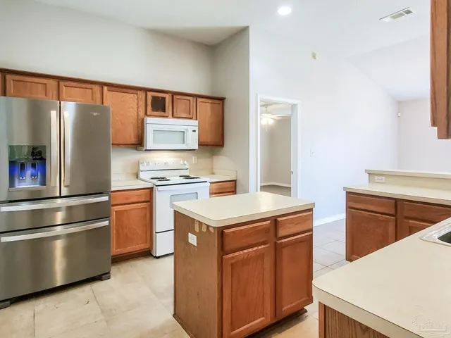 a kitchen with stainless steel appliances granite countertop a refrigerator and a stove