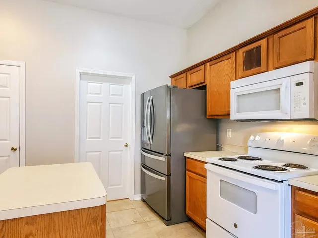 a kitchen with stainless steel appliances granite countertop a refrigerator and a stove