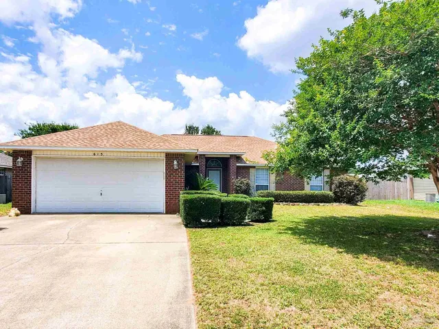 a front view of a house with a garden and yard