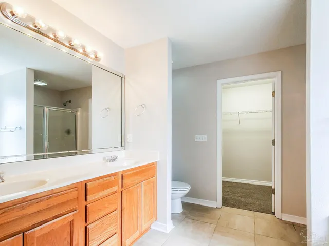 a spacious bathroom with a shower sink and mirror