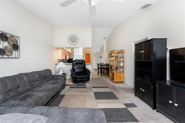 a living room with furniture a flat screen tv and a rug
